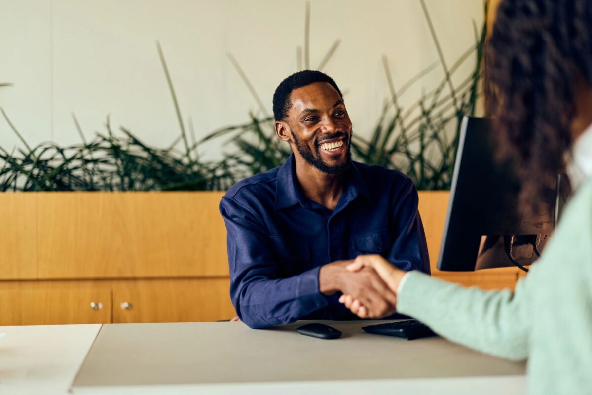 Two professionals shaking hands across a desk